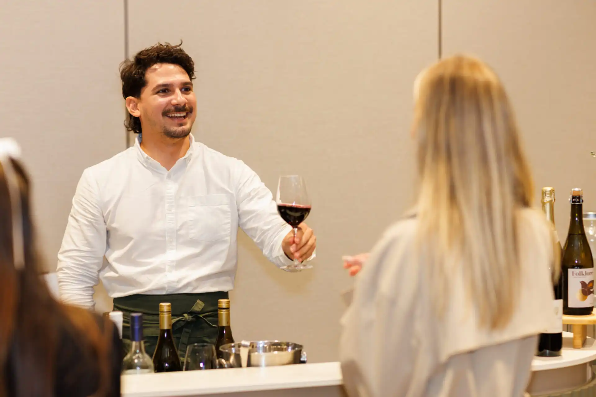 Bartender serving wine to guest at indoor wedding or event reception